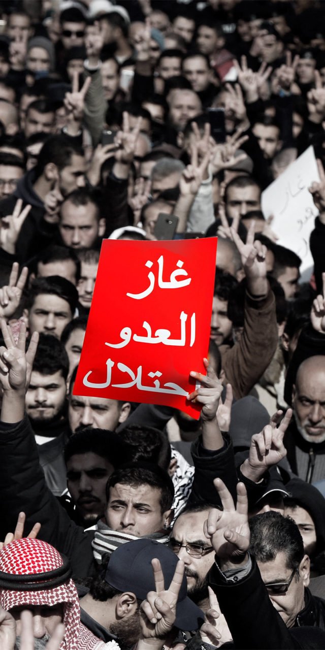 Jordanian demonstrators chant slogans during a protest against a government agreement to import natural gas from Israel, in Amman, Jordan, January 3, 2020. The red placard reads: "The enemy's gas is occupation". REUTERS/Muhammad Hamed